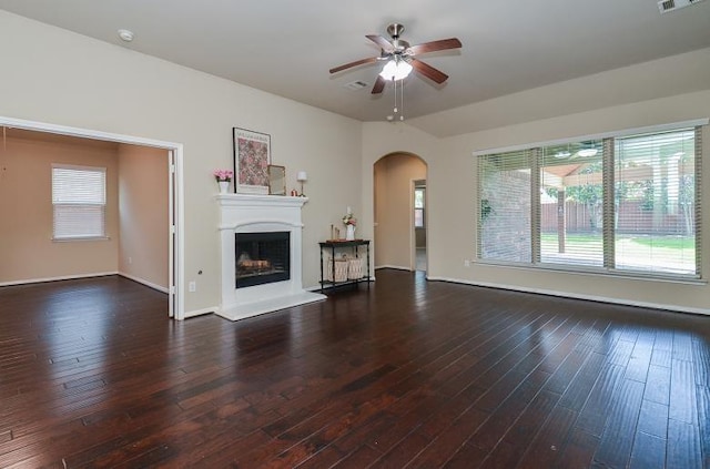 4327 Estes Ridge Ln, Katy, TX 77493 - unfurnished living room with arched walkways, ceiling fan, hardwood / wood-style flooring, and a fireplace with raised hearth