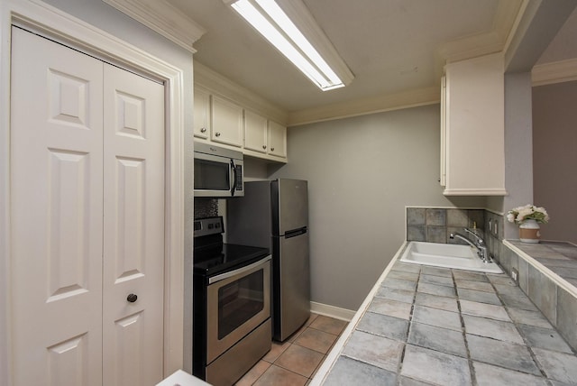 9005 Gaylord St Unit 19, Houston, TX 77024 - kitchen with appliances with stainless steel finishes, tile counters, ornamental molding, white cabinets, and light tile patterned flooring
