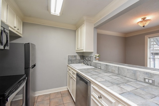 9005 Gaylord St Unit 19, Houston, TX 77024 - kitchen with tile counters, stainless steel appliances, decorative backsplash, white cabinets, and crown molding