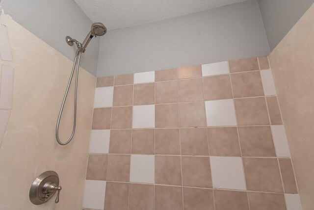 9005 Gaylord St Unit 19, Houston, TX 77024 - full bathroom featuring tiled shower and a textured ceiling