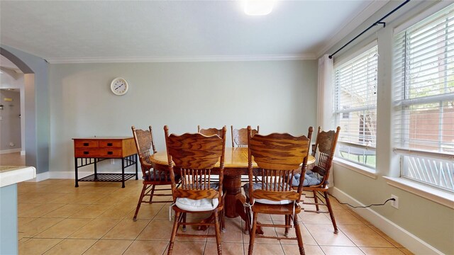 1309 Bayswater Dr, Houston, TX 77047 - dining room featuring arched walkways, light tile patterned floors, and crown molding