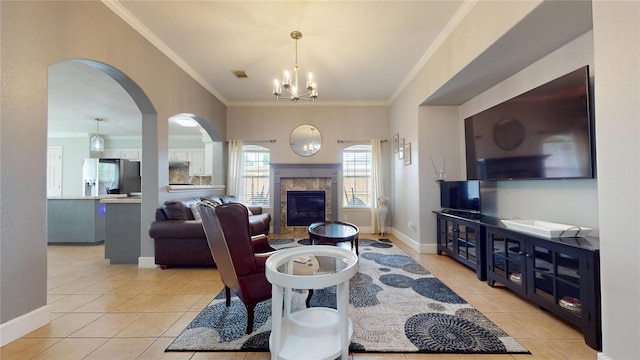 1309 Bayswater Dr, Houston, TX 77047 - living room featuring light tile patterned floors, crown molding, a chandelier, arched walkways, and a tile fireplace