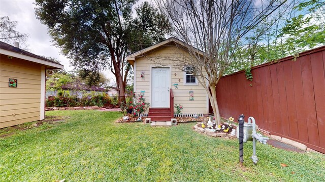 1309 Bayswater Dr, Houston, TX 77047 - view of front of house with entry steps, a fenced backyard, and an outdoor structure