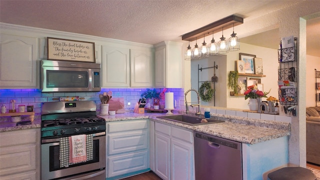 141 Cypress Dr, Richwood, TX 77531 - kitchen with appliances with stainless steel finishes, white cabinetry, backsplash, light countertops, and a textured ceiling