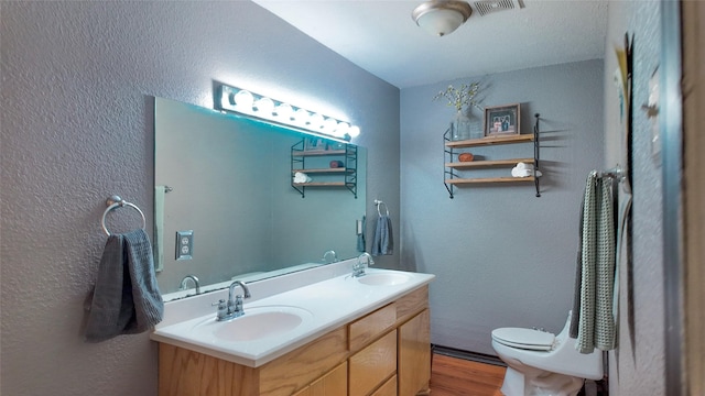 141 Cypress Dr, Richwood, TX 77531 - bathroom featuring wood finished floors, a textured wall, and double vanity