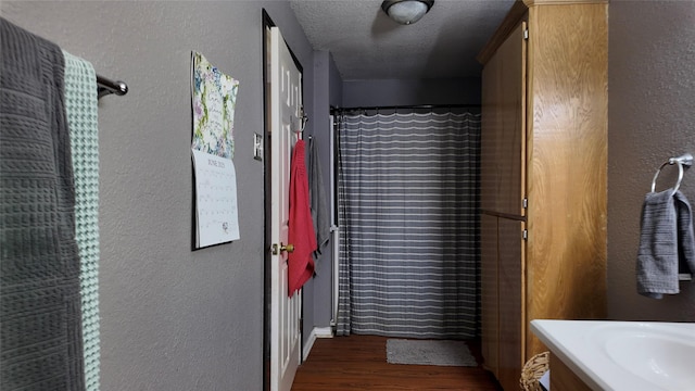 141 Cypress Dr, Richwood, TX 77531 - full bath with a textured wall, vanity, wood finished floors, a textured ceiling, and a shower with shower curtain