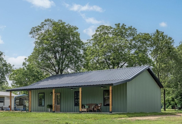 228 Cherry, Lexington, TX 78947 - view of front facade featuring ceiling fan, a front lawn, board and batten siding, and a metal roof