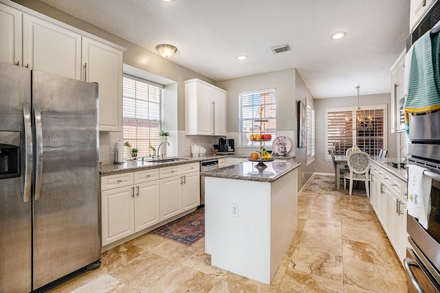 2602 Orleans Dr, Seabrook, TX 77586 - kitchen featuring appliances with stainless steel finishes, a kitchen island, healthy amount of natural light, backsplash, and recessed lighting