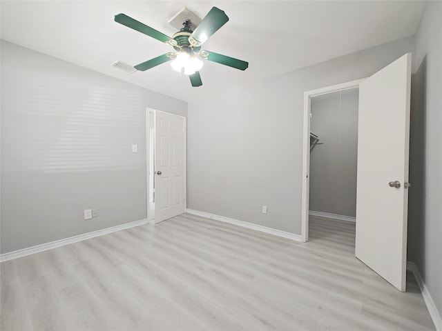 8818 Roos Rd, Houston, TX 77036 - unfurnished bedroom with light wood-type flooring, ceiling fan, a closet, and a spacious closet