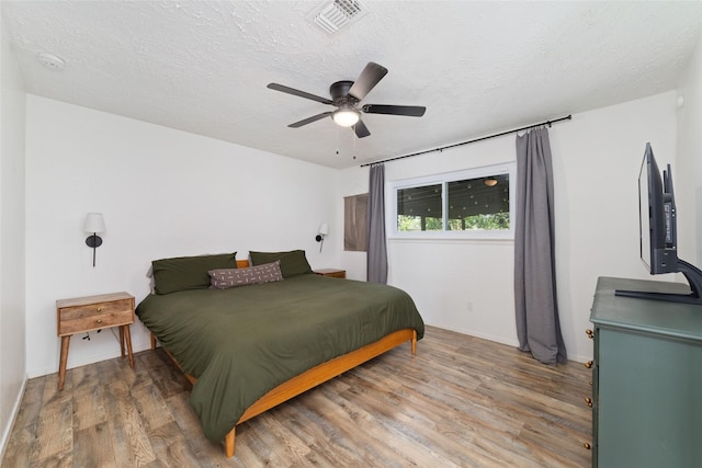 3543 Acorn Springs Ln, Spring, TX 77389 - bedroom with light wood-type flooring, a textured ceiling, and a ceiling fan