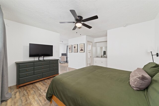 3543 Acorn Springs Ln, Spring, TX 77389 - bedroom featuring wood finished floors, ensuite bathroom, a textured ceiling, and ceiling fan