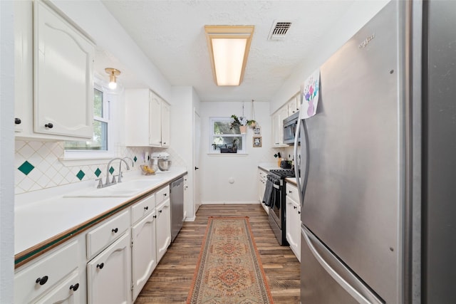 3543 Acorn Springs Ln, Spring, TX 77389 - kitchen featuring stainless steel appliances, dark wood-type flooring, white cabinetry, tasteful backsplash, and plenty of natural light