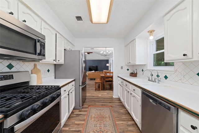 3543 Acorn Springs Ln, Spring, TX 77389 - kitchen with appliances with stainless steel finishes, wood finished floors, light countertops, and white cabinets