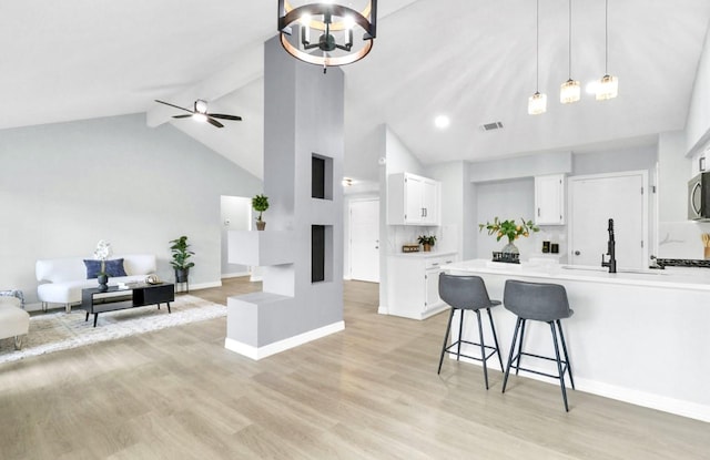 16307 N Mist Dr, Houston, TX 77073 - kitchen featuring open floor plan, white cabinets, a kitchen bar, high vaulted ceiling, and pendant lighting