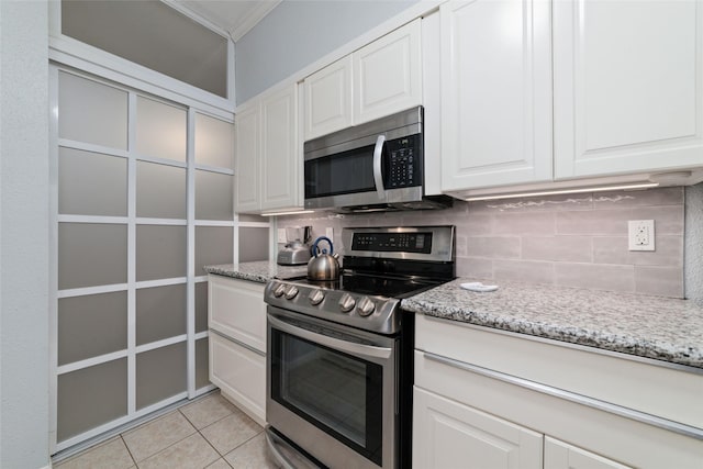 2400 N Braeswood Blvd Unit 108, Houston, TX 77030 - kitchen featuring appliances with stainless steel finishes, backsplash, light stone countertops, white cabinetry, and crown molding