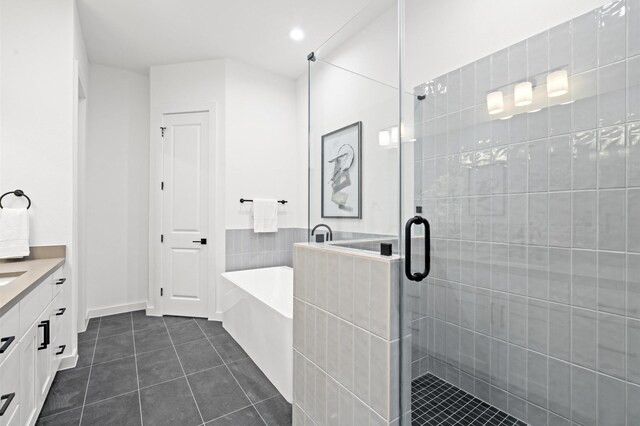 6417 Madrid St, Houston, TX 77021 - full bathroom featuring vanity, tile patterned floors, a bath, a stall shower, and recessed lighting
