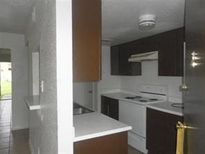 12308 Ormandy St, Houston, TX 77085 - kitchen featuring electric range, exhaust hood, light countertops, and modern cabinets