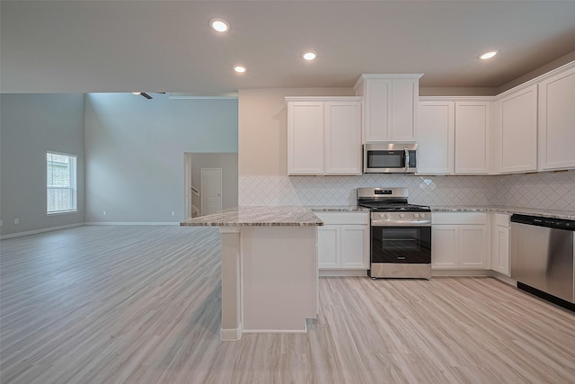 27222 Clear Breeze Dr, Katy, TX 77493 - kitchen with appliances with stainless steel finishes, open floor plan, backsplash, light wood-style floors, and light stone countertops