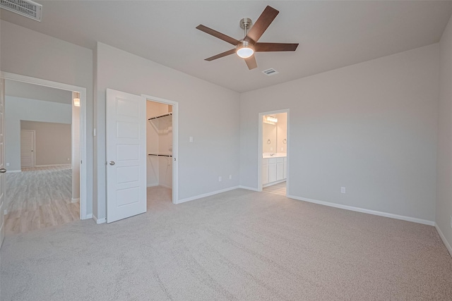 27222 Clear Breeze Dr, Katy, TX 77493 - unfurnished bedroom featuring light carpet, a walk in closet, ceiling fan, ensuite bathroom, and a closet