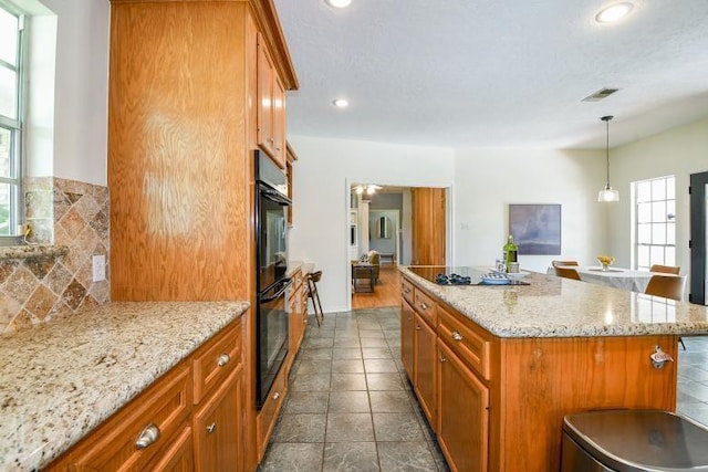 22035 Buescher Rd, Tomball, TX 77377 - kitchen featuring plenty of natural light, brown cabinets, a center island, and recessed lighting