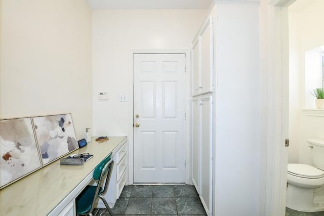 22035 Buescher Rd, Tomball, TX 77377 - office area featuring built in desk and dark tile patterned flooring