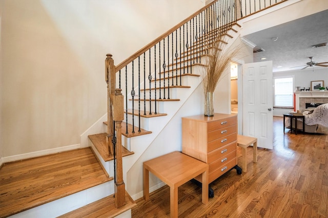 802 Lamonte, Houston, TX 77018 - stairs with wood finished floors, a tiled fireplace, and ceiling fan