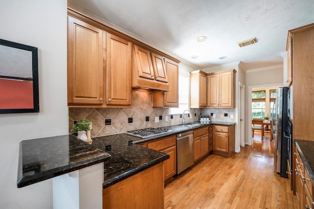 802 Lamonte, Houston, TX 77018 - kitchen with appliances with stainless steel finishes, crown molding, light wood-style floors, plenty of natural light, and a peninsula