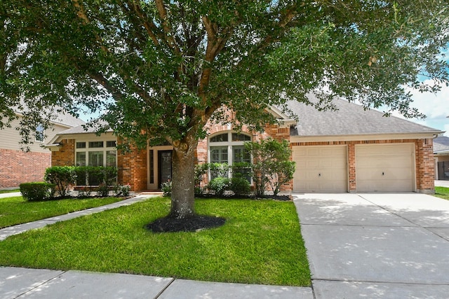 26622 Boulder Cove Ct, Katy, TX 77494 - view of property hidden behind natural elements featuring an attached garage, a front yard, brick siding, and driveway