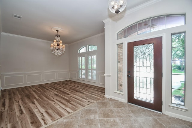 26622 Boulder Cove Ct, Katy, TX 77494 - foyer entrance with a chandelier, crown molding, a decorative wall, wainscoting, and tile patterned flooring