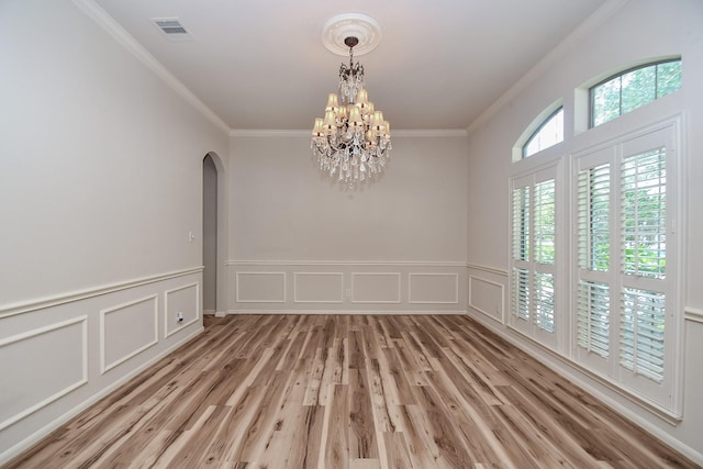 26622 Boulder Cove Ct, Katy, TX 77494 - spare room with ornamental molding, arched walkways, a chandelier, light wood finished floors, and a decorative wall
