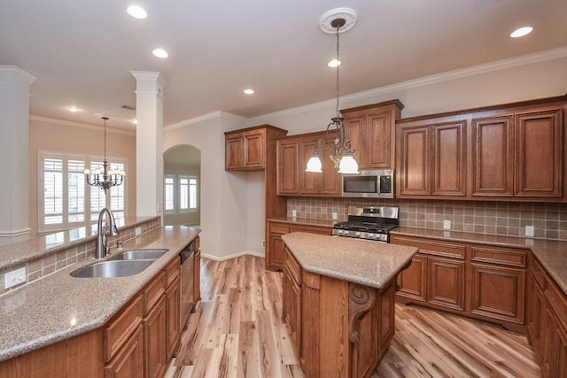 26622 Boulder Cove Ct, Katy, TX 77494 - kitchen with stainless steel appliances, brown cabinets, a kitchen island, light wood-style floors, and light stone counters