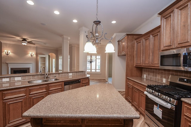 26622 Boulder Cove Ct, Katy, TX 77494 - kitchen featuring appliances with stainless steel finishes, brown cabinets, tasteful backsplash, ornamental molding, and a ceiling fan