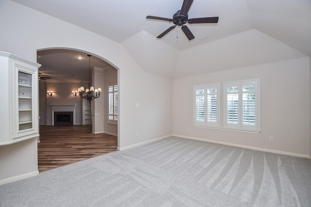 26622 Boulder Cove Ct, Katy, TX 77494 - carpeted empty room with ceiling fan, a fireplace, arched walkways, a chandelier, and vaulted ceiling