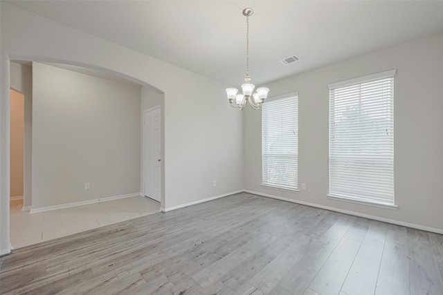 23607 Acerola Tree Ct, Katy, TX 77493 - unfurnished room with arched walkways, a chandelier, and light wood-style floors