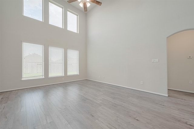 23607 Acerola Tree Ct, Katy, TX 77493 - unfurnished room with arched walkways, ceiling fan, a high ceiling, and light wood-style flooring