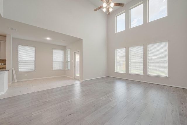 23607 Acerola Tree Ct, Katy, TX 77493 - unfurnished living room featuring ceiling fan, a high ceiling, and light wood finished floors
