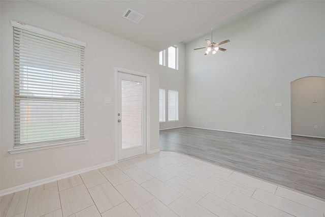 23607 Acerola Tree Ct, Katy, TX 77493 - unfurnished room featuring a ceiling fan, arched walkways, a towering ceiling, and light tile patterned flooring