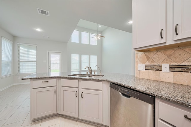 23607 Acerola Tree Ct, Katy, TX 77493 - kitchen with dishwasher, light stone countertops, a ceiling fan, backsplash, and a peninsula
