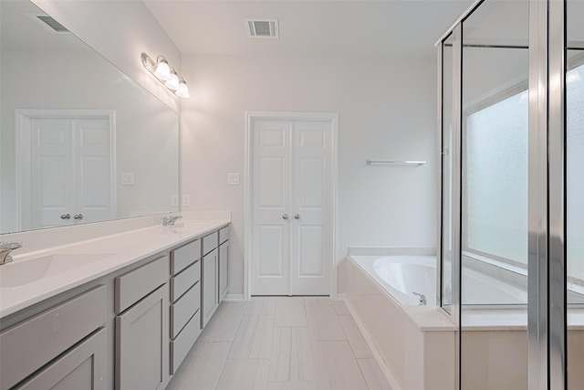 23607 Acerola Tree Ct, Katy, TX 77493 - full bathroom with double vanity, a garden tub, and a shower with door