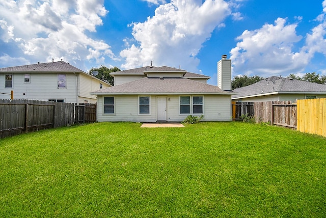 19727 Hon Ct, Katy, TX 77449 - rear view of house with a fenced backyard, a shingled roof, a patio, and a chimney