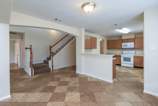 19727 Hon Ct, Katy, TX 77449 - kitchen featuring white appliances, arched walkways, light countertops, brown cabinets, and a peninsula