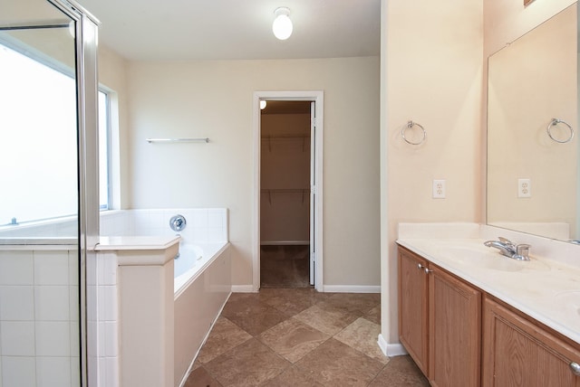19727 Hon Ct, Katy, TX 77449 - bathroom featuring a bath, double vanity, a spacious closet, and an enclosed shower