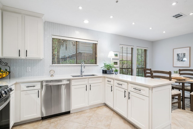 291 E Rainbow Ridge Cir, The Woodlands, TX 77381 - kitchen featuring stainless steel appliances, recessed lighting, a peninsula, light countertops, and decorative backsplash