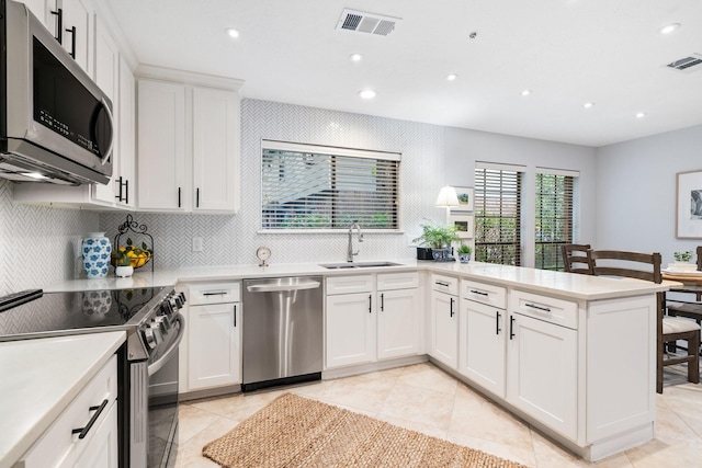 291 E Rainbow Ridge Cir, The Woodlands, TX 77381 - kitchen with appliances with stainless steel finishes, recessed lighting, a peninsula, light countertops, and backsplash