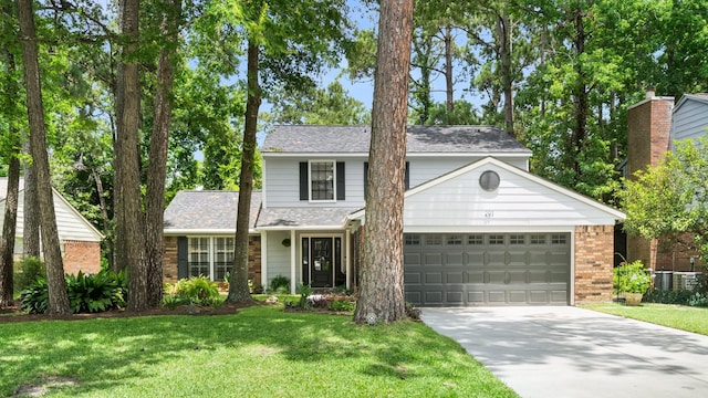 291 E Rainbow Ridge Cir, The Woodlands, TX 77381 - traditional-style house with concrete driveway, a garage, a front yard, brick siding, and a shingled roof