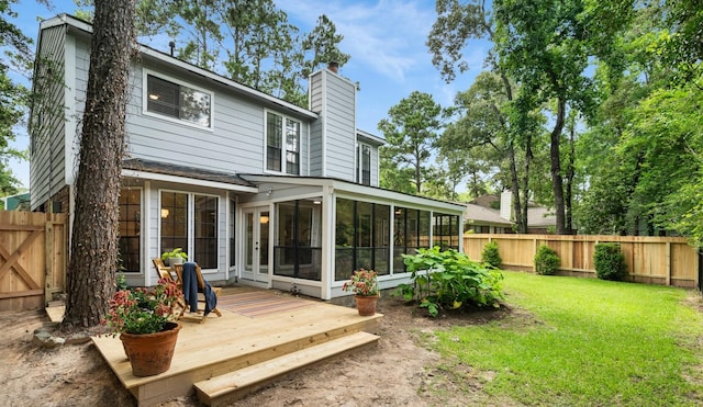291 E Rainbow Ridge Cir, The Woodlands, TX 77381 - rear view of house featuring a sunroom, a fenced backyard, a chimney, and a wooden deck