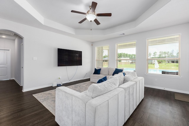 2018 Rd 660, Dayton, TX 77535 - living room with a tray ceiling, a ceiling fan, arched walkways, and dark wood-style flooring