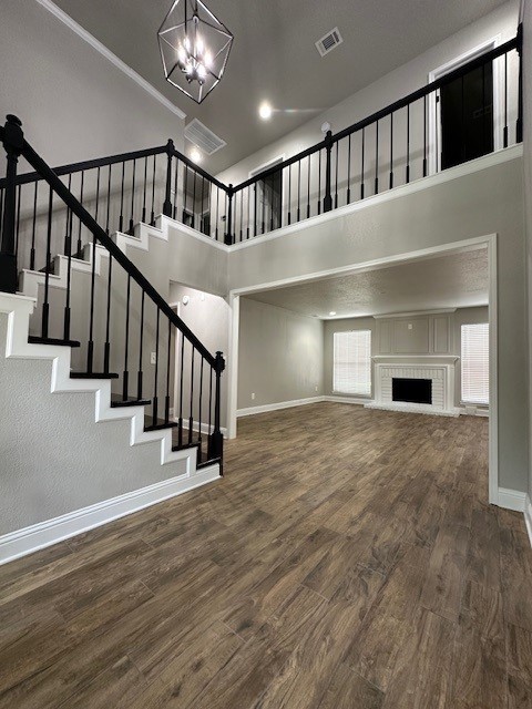 2102 Autumn Cove Dr, League City, TX 77573 - unfurnished living room featuring a high ceiling, a chandelier, wood finished floors, stairway, and plenty of natural light