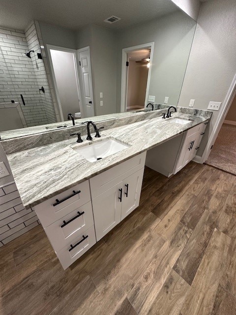 2102 Autumn Cove Dr, League City, TX 77573 - full bath with double vanity, a tile shower, and wood finished floors