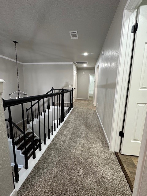 2102 Autumn Cove Dr, League City, TX 77573 - corridor featuring attic access, an upstairs landing, carpet flooring, a textured ceiling, and crown molding